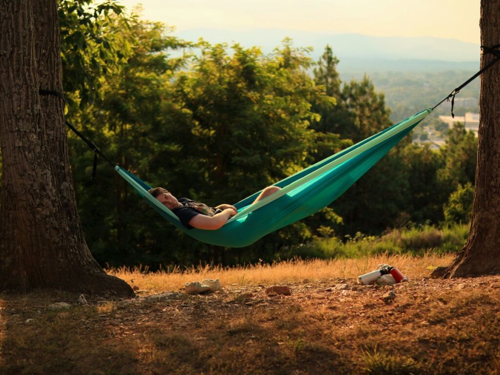 homme dans un hamac, en pleine nature, les train de lacher prise et de se ressourcer 