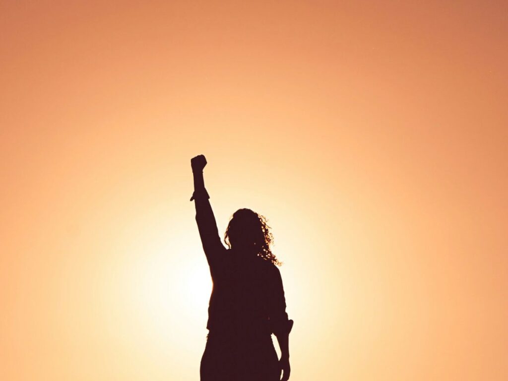 Femme point levé au ciel, devant le sunset