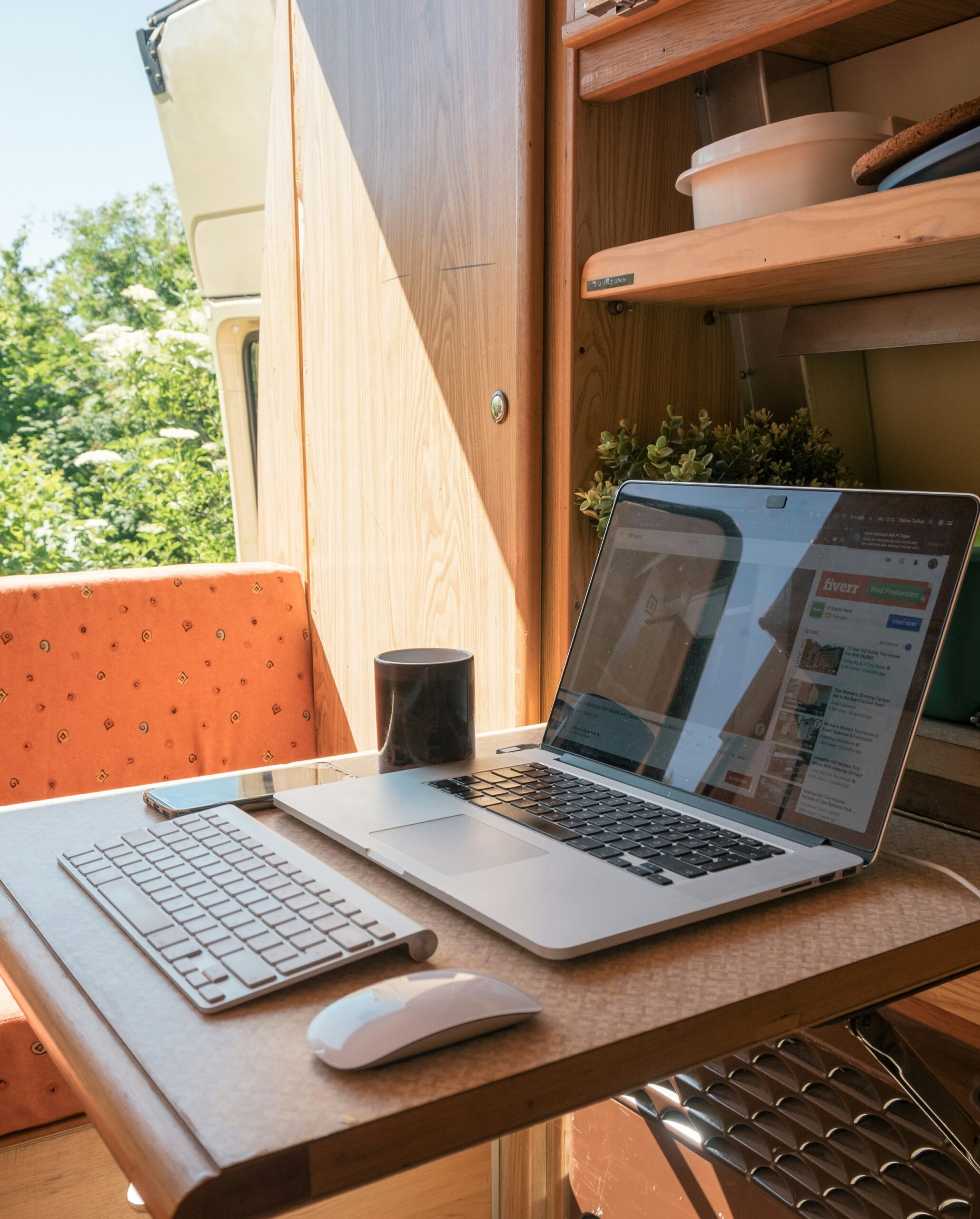 digital nomad Ordinateur portable installé sur une tablette, dans un van porte ouvert sur un environnement agréable et ensoleillé, c'est un rituel d'un digital nomad