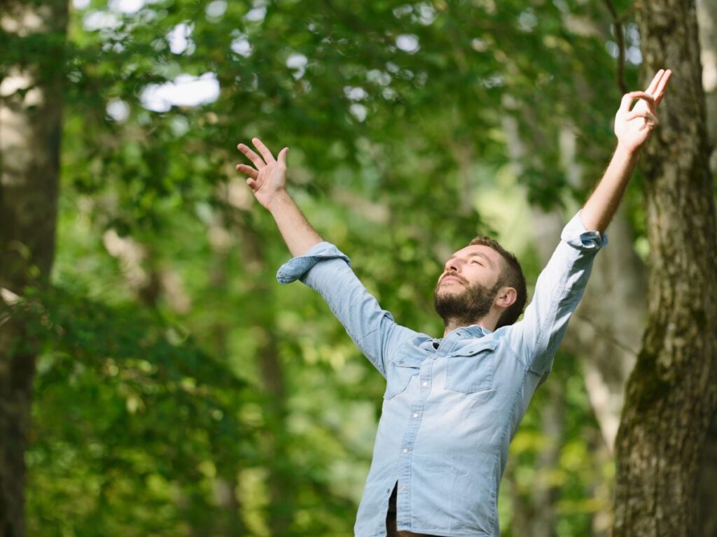 Homme libre, levant les bras en pleine nature