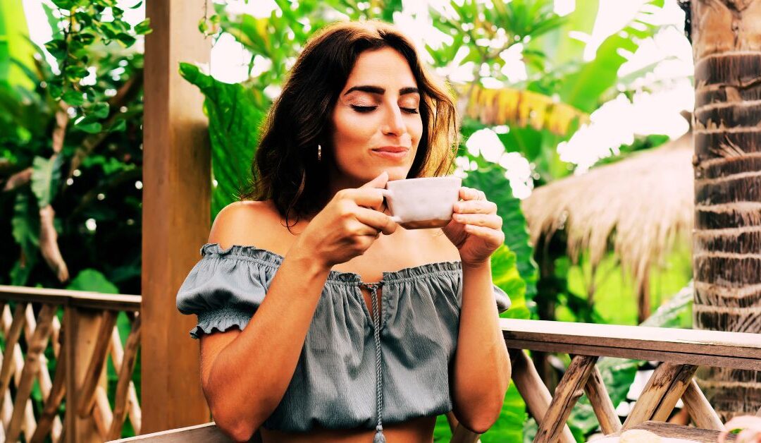 Femme, à la terrasse d'un café, en train de savourer l'instant présent