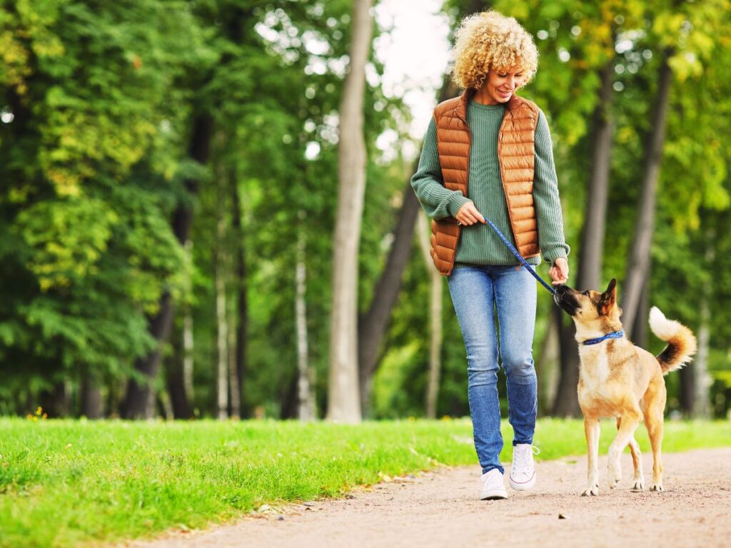 Marcher pour faire le vide et se reconnecter à soi Femme qui marche avec son chien, pour faire le vide et se reconnecter à soi